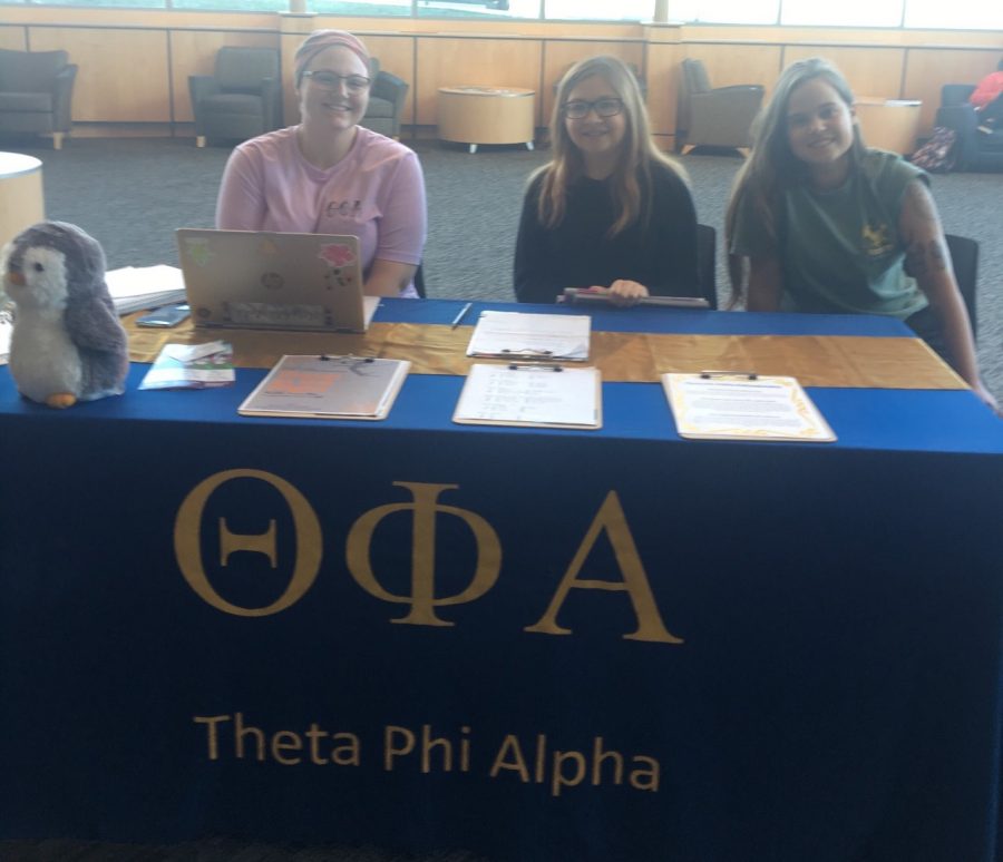 The image is the Theta Phi Alpha table in the university center.  They are promoting the tournament and taking registrations.

Pictured in the image (from left to right): Ali Boyd, Kara Smith, and Cami Shoemaker
