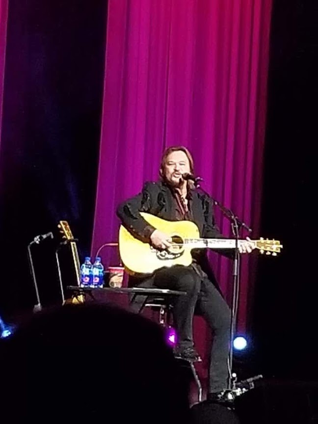 Travis Tritt on stage singing and playing for the crowd. Photo by Victoria Reffit.